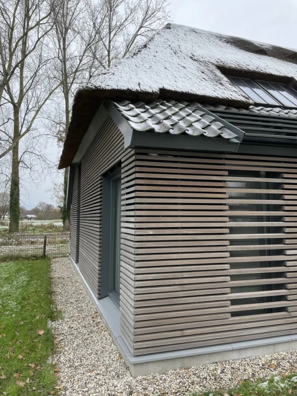 Loopbrug, leuningen, stalen pui en waterslagen in moderne boerderij