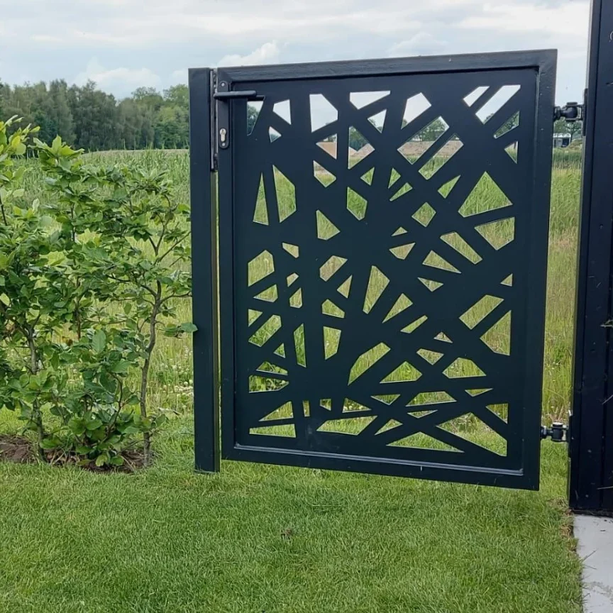 Zwart stalen tuinpoortje met decoratief uitgesneden patroon