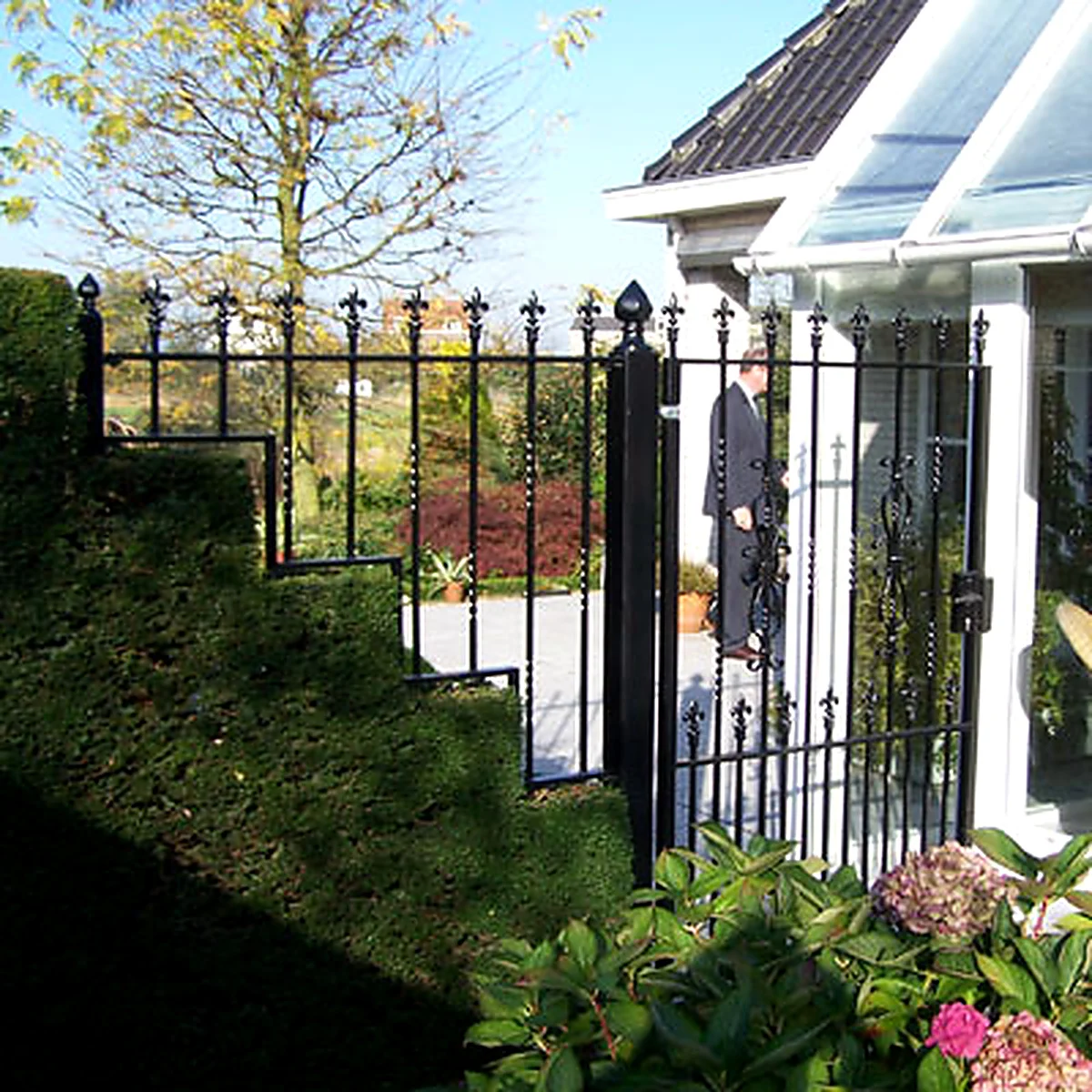 Zwarte stalen tuinpoort met spijlen en decoratieve punten bij een woning in Heesch.