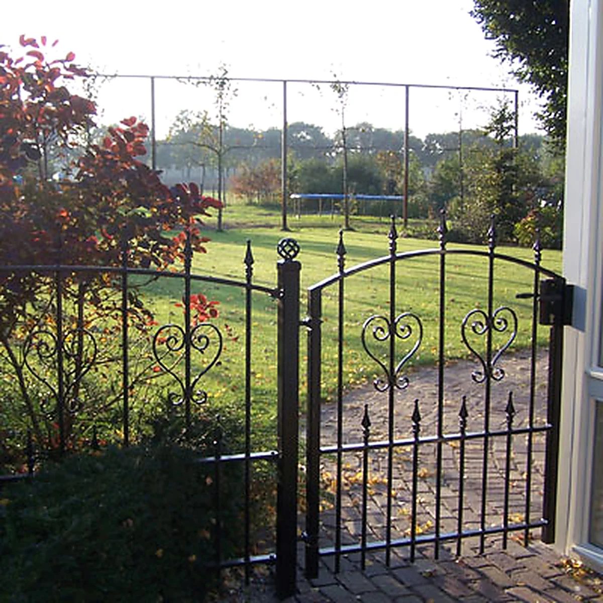 Stalen tuinpoort met sierkrullen, verticale spijlen en decoratieve punten in Vinkel.